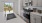 a kitchen with white cabinets a sink a stovetop and large windows