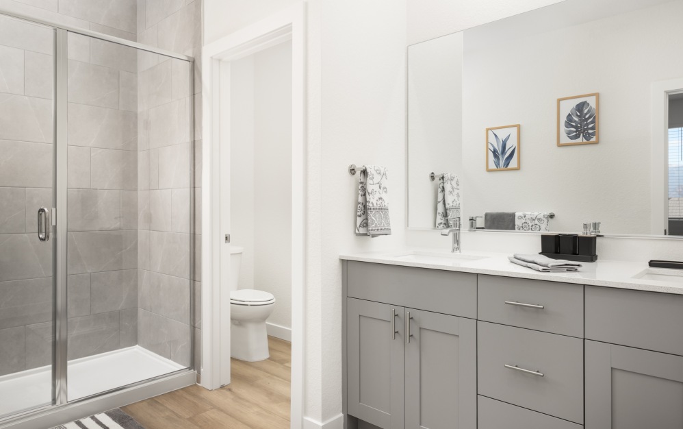 Primary bathroom with dual sink vanity and glass enclosed shower at The Selby