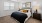 a bedroom with a bed and a fan and windows